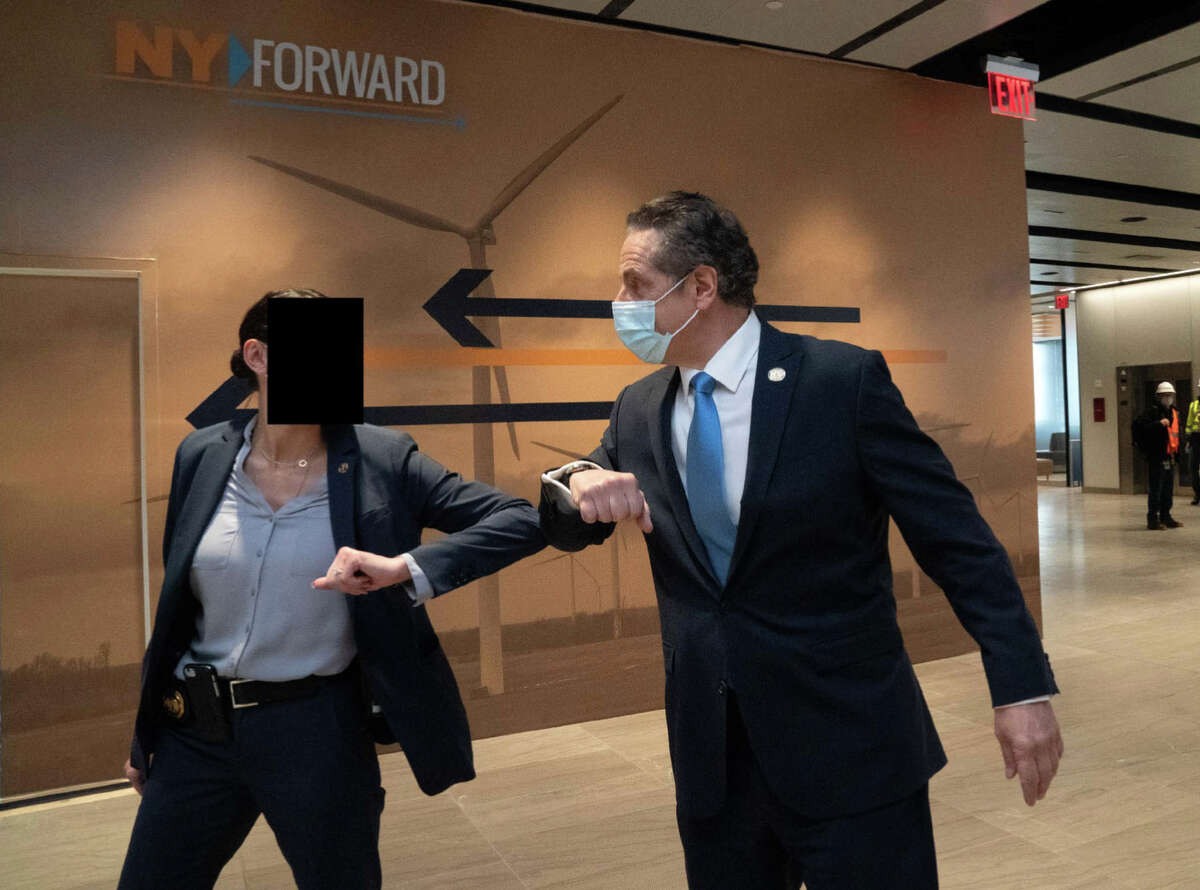 Former Gov. Andrew M. Cuomo bumps elbows with a 30-year-old female trooper at an event at Penn Station in Manhattan in December, 2020. Cuomo has been accused of sexually harassing the trooper after he directed members of his Protective Services Detail to offer her a job on the unit in 2017. (Photo courtesy former Gov. Andrew M. Cuomo via Rita Glavin, Cuomo's attorney)