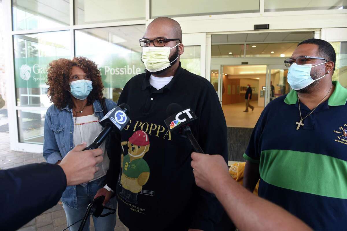 Glenn Merritt III, center, of New Haven with his parents, Linette, left, and Glenn Merritt Jr., speaks with the press following his release from Gaylord Hospital in Wallingford Oct. 22, 2021.