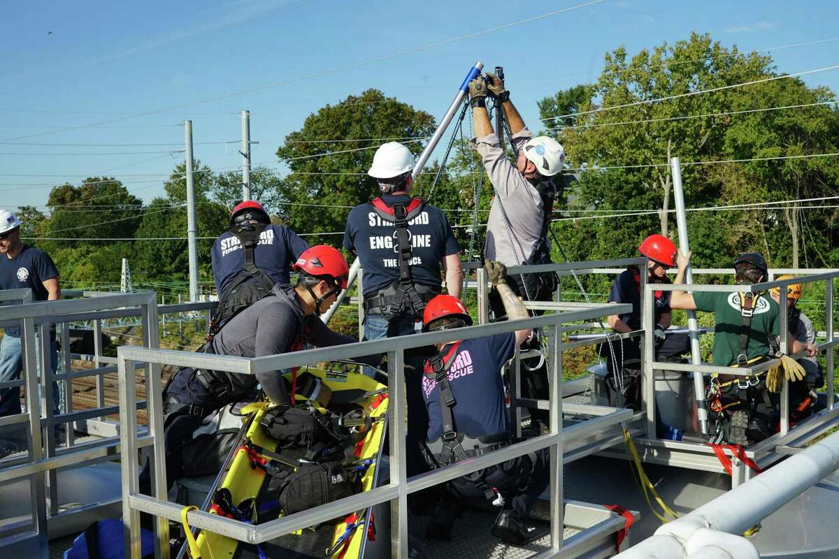 Members of the Stratford Fire Department practice securing a stokes basket to a high point on the roof of Two Roads Brewery on Oct. 21.