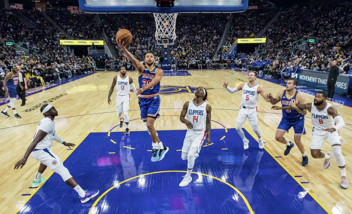 With all five Clippers’ defenders serving as witnesses, the Warriors’ Stephen Curry puts up a shot in the first half of Thursday’s game at Chase Center.