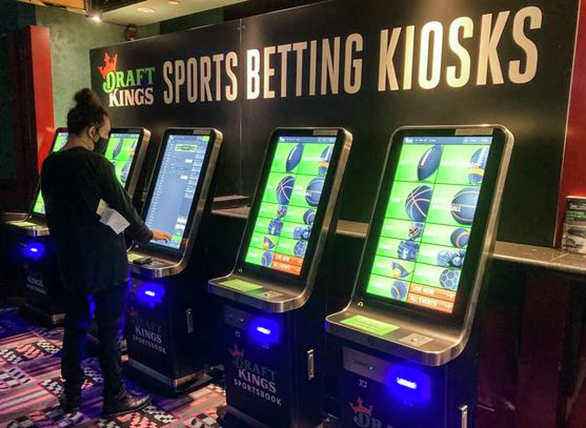 Zach Young places a bet at one of the new sports wagering kiosks at Foxwoods Resort Casino in Mashantucket, Conn. Proposed ballot measures seek to legalize sports betting in California.