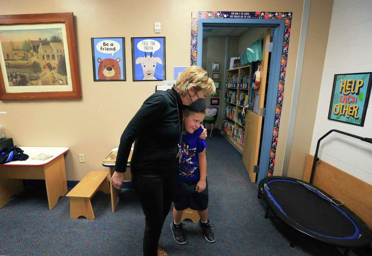 School counselor Janice Lanford and a second-grade student exchange a hug after a one-on-one meeting at Wilderness Oak Elementary School on Monday. As students return to classes this fall, school districts have been seeing record numbers of them using mental health resources.