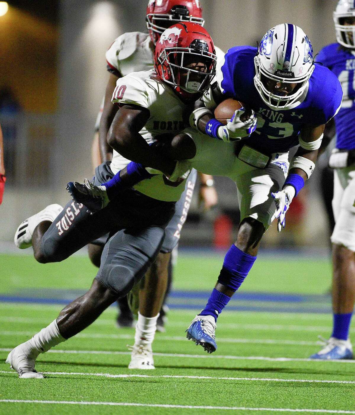 C.E. King running back DK Hammond, right, is tackled for a loss by North Shore linebacker Kent Battle during the first half of a high school football game, Friday, Oct. 22, 2021, in Houston.