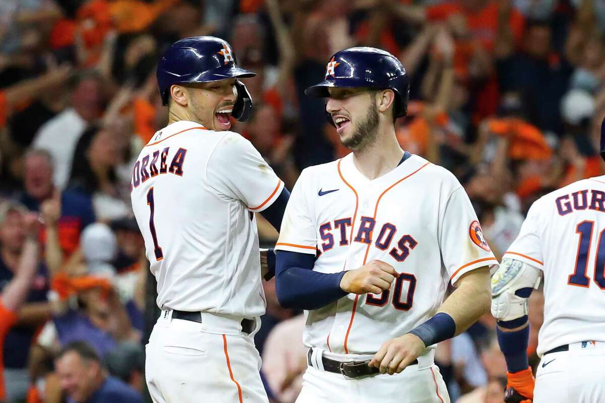Kyle Tucker (30) is met at home by Houston Astros shortstop Carlos Correa (1) and Houston Astros left fielder Michael Brantley (23) after he hits a three-run home run to give the Astros a 5-0 lead in the bottom of the eighth inning in Game 6 of the American League Championship Series on Friday, Oct. 22, 2021 at Minute Maid Park in Houston.
