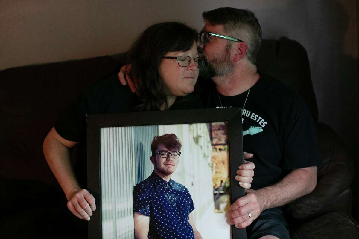 Troy and Cheryl Estes, the parents of Dru Estes, hold their son’s portrait at their San Antonio home. Dru was one of five people killed in an intentionally set fire at Iconic Village Apartments in San Marcos in 2018. The case remains unsolved.