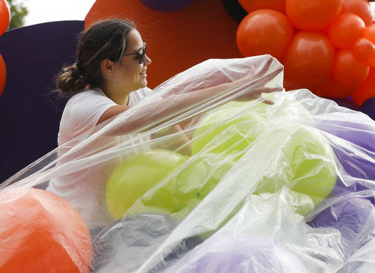 Alecia Young gathers balloon for a display during Halloween in the Park at Carl Barton, Jr. Park, Saturday, Oct. 23, 2021, in Conroe.