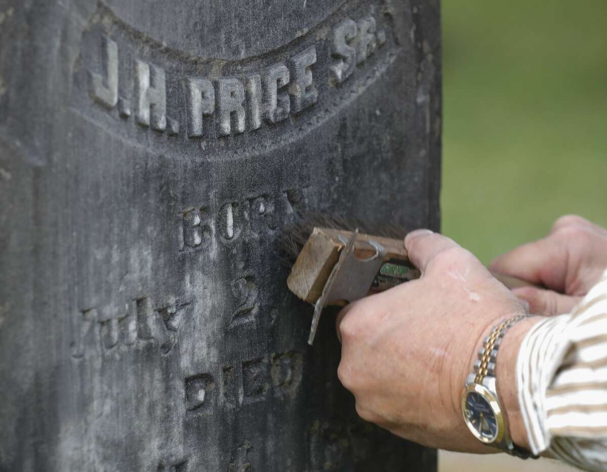 Reenactor David Hamaker uses a brush and water to clean a gravestone as the Montgomery Historical Society holds its annual Voices from the Past Cemetery tour on Saturday, October 23, 2021, in Montgomery. Reenactors, dressed in period clothing, led small-group tours to each of the city's three historic cemeteries for those interested in the region's long and colorful history and genealogy.