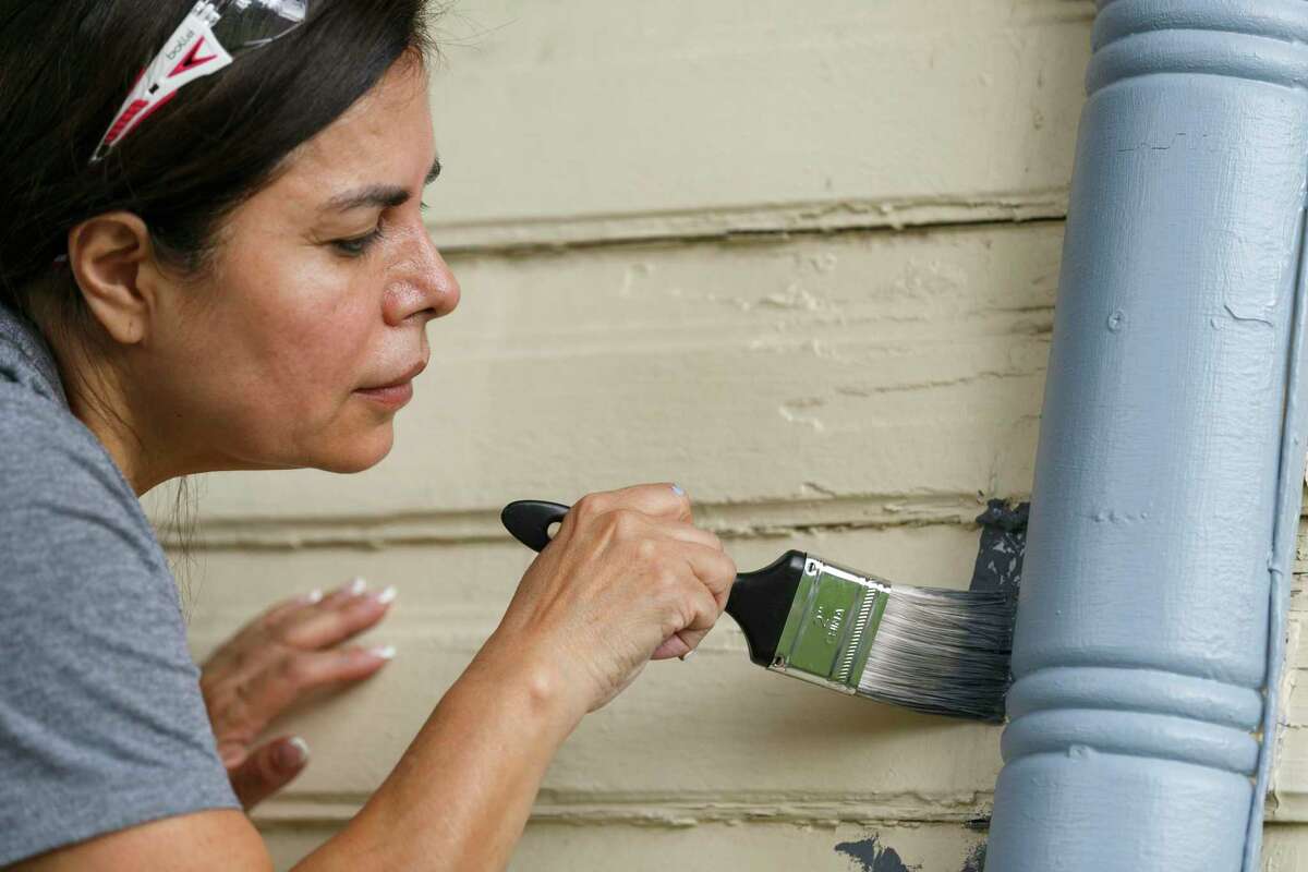 San Antonio College student volunteer Martha Vidana helps repaint a house on Monterey Street on Saturday during Rehabarama, which was was started to help homeowners by offering free basic maintenance assistance.