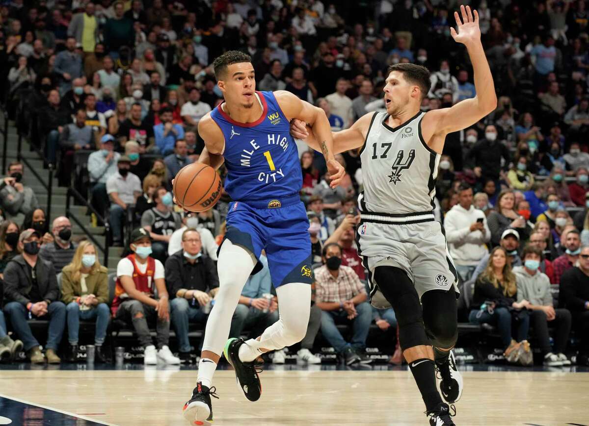 Denver Nuggets forward Michael Porter Jr., left, is defended by San Antonio Spurs guard Doug McDermott during the second half of an NBA basketball game Friday, Oct. 22, 2021, in Denver. The Nuggets won 102-96. (AP Photo/David Zalubowski)