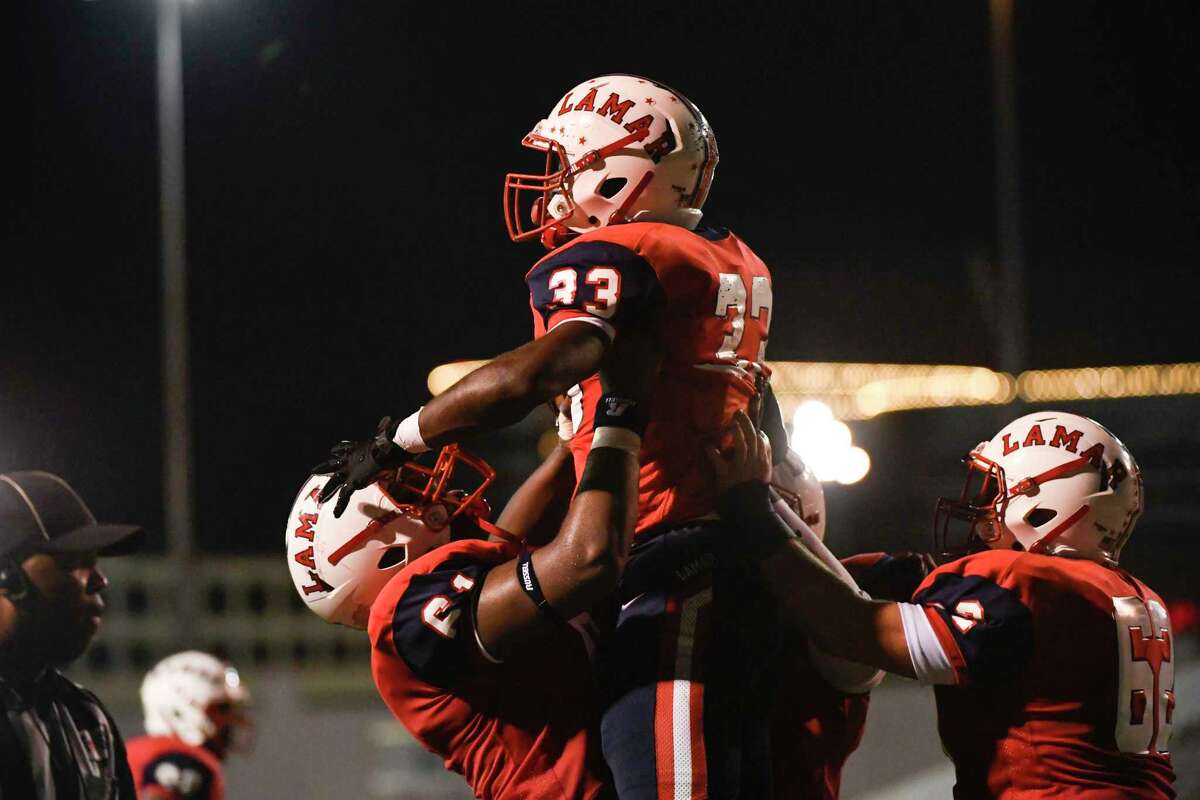 Lamar’s Raylon Sparrow (61) picks up Kenneth Kennedy (33) after he scored a touchdown against Lamar during a District 18-6A high school football game Saturday, Oct. 23, 2021, at Delmar Stadium in Houston.