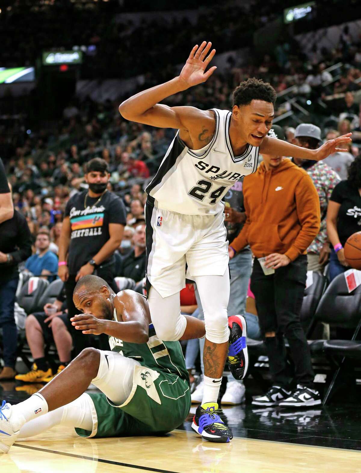 Devin Vassell #24 of the San Antonio Spurs tries to avoid the foul on Milwaukee Bucks Khris Middleton. Milwaukee Bucks defeated the San Antonio Spurs 121-111 at the AT&T Center I on Saturday Oct. 23, 2021.