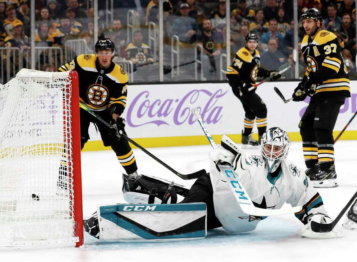 As Boston Bruins' Patrice Bergeron (37) and Brad Marchand look on, San Jose Sharks goaltender Martin Jones can't stop a goal by Boston Bruins' David Pastrnak during the first period of an NHL hockey game, Tuesday, Oct. 29, 2019, in Boston. (AP Photo/Winslow Townson)