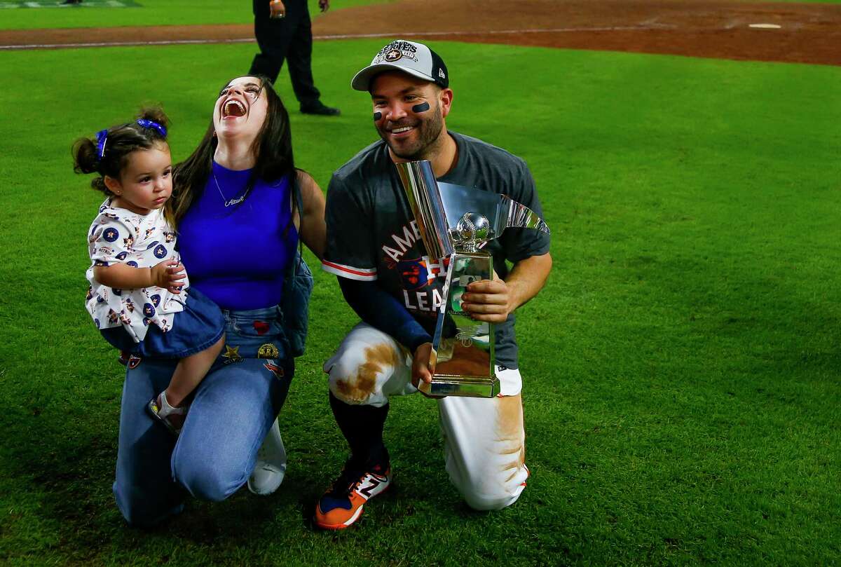 Le joueur de deuxième but des Astros de Houston, Jose Altuve (27 ans), et sa femme, Nina, rient en prenant une photo avec le trophée ALCS après le sixième match de la série de championnats de la Ligue américaine le vendredi 22 octobre 2021 au Minute Maid Park de Houston.