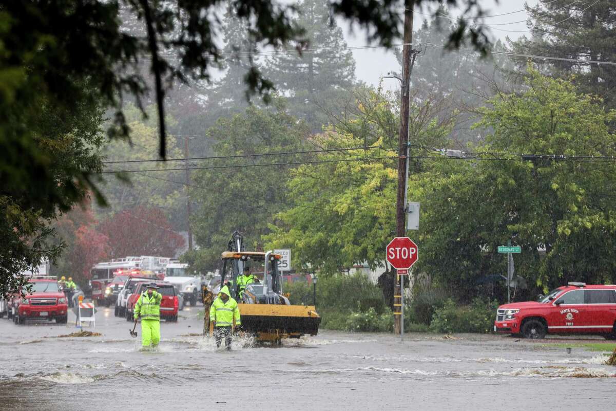 Crews work to ease flood waters in a neighborhood with the use of mud, gravel and a dozer in Santa Rosa, Calif. on Sunday, Oct. 24, 2021. Deemed by meteorologist as an “atmospheric river,” a series of rain storms continues to drench the Bay Area making it one of the biggest storms of the year.
