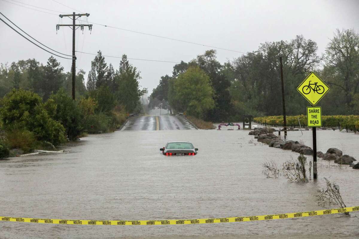 A vehicle sits in floodwaters near the Russian River off River and Slusser roads in Forestville.