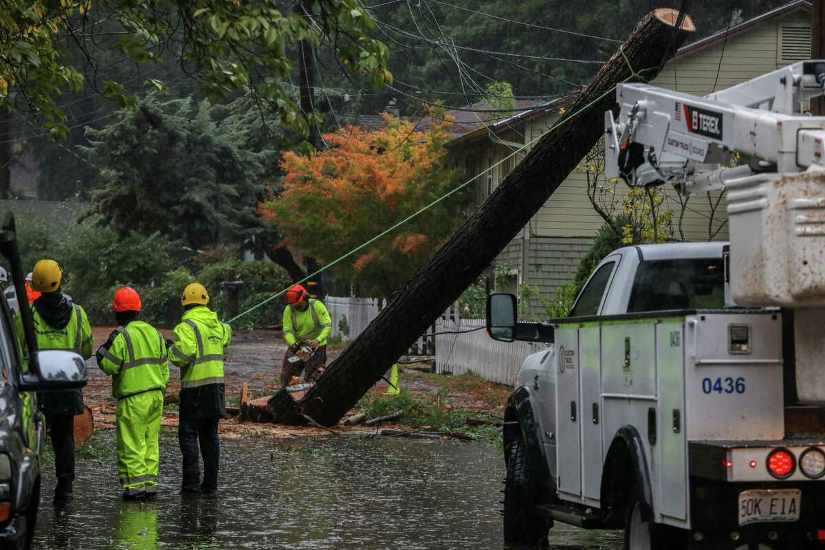Crews work to removed a downed tree trunk near Guerneville following the “atmospheric river” storm. PG&E said several thousand Bay Area customers remained without power.