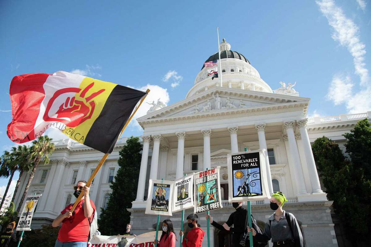 Activists from the Sunrise Movement and a coalition of environmental and Indigenous groups march to the California Capitol in Sacramento on Friday, demanding the state Democratic Party ban contributions from fossil fuel and law enforcement groups.
