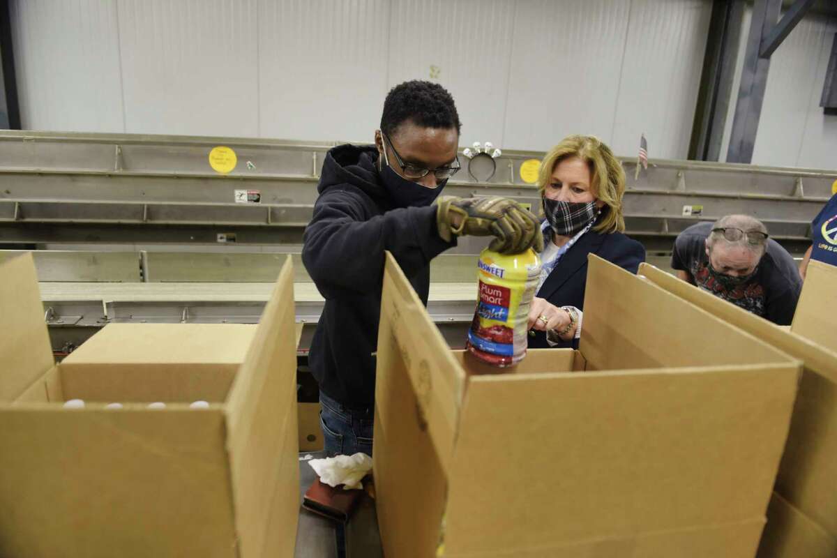 Tajalee Andrews, left, a warehouse assistant at the Regional Food Bank of Northeastern New York, and food bank CEO, Molly Nicol, in the salvage sorting room on Tuesday, Oct. 12, 2021, in Latham, N.Y.