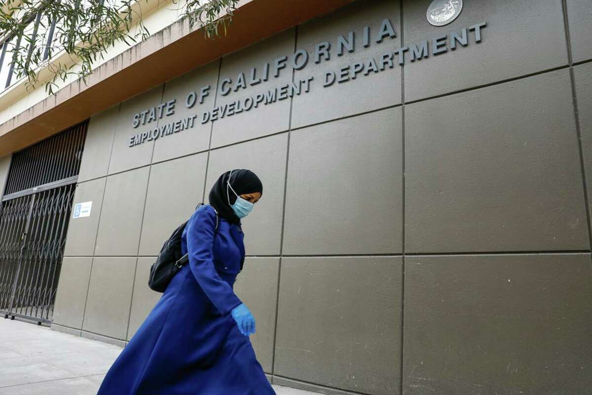 A woman walks by the S.F. office of the Employment Development Department in 2020. The EDD was grilled by lawmakers on progress in its overhaul.