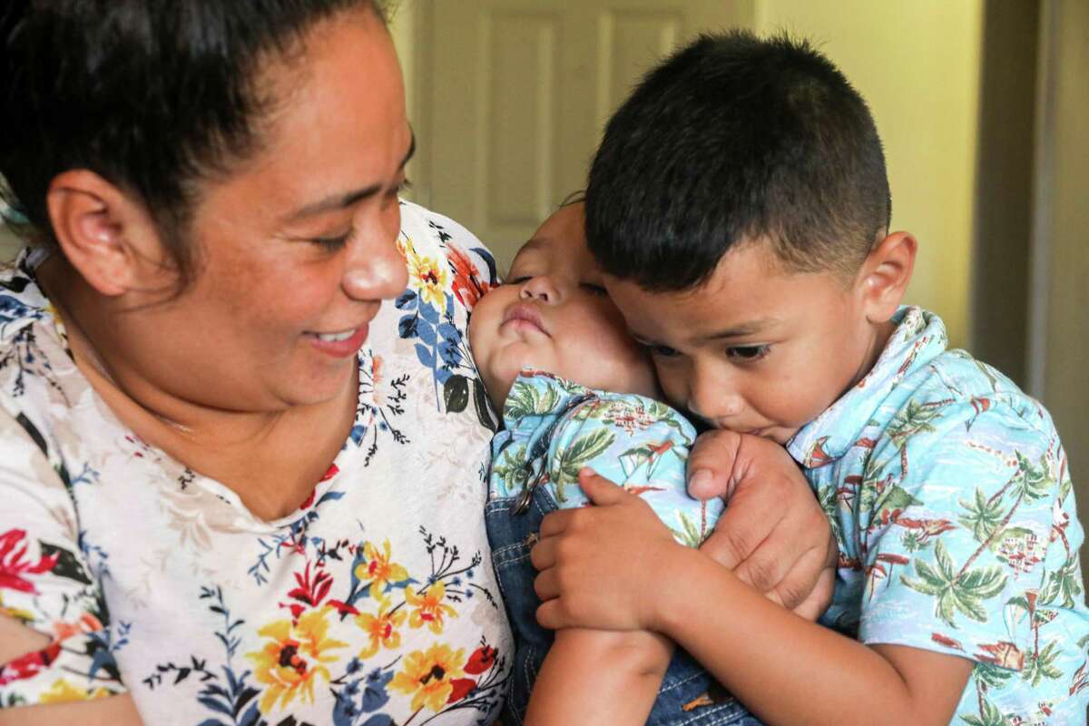 Mirna Arana holds her 10-month-old son, Alan, while playing with Aaron, 3. Arana is hopeful about a new plan that would give domestic workers paid sick leave, which she could also use to take her children to the doctor.