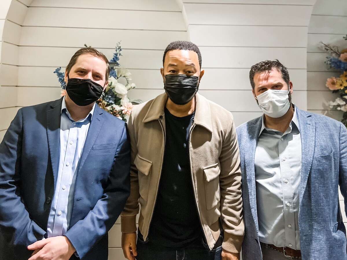 After "All of Me" singer John Legend's tour stop at Foxwoods Resort Casino on Oct. 16, 2021, Legend dined at Italian restaurant Caputo Trattoria with wife Chrissy Teigen and kids Luna and Miles. Legend is pictured with two staff members at Caputo Trattoria. 