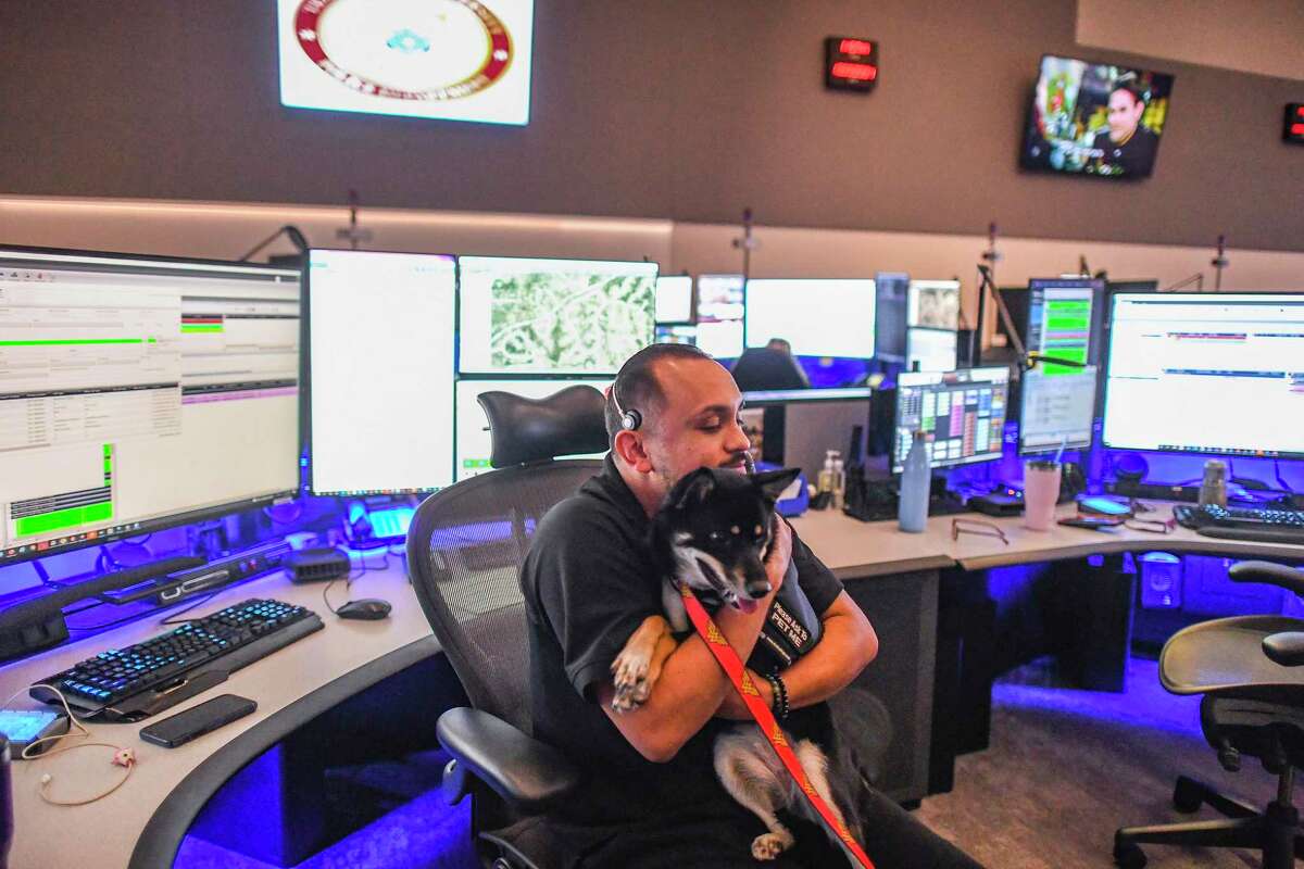 Hays County dispatcher Manny Olivas hugs Sophie, a therapy dog with the San Marcos Police Department, on Monday, Oct. 25, 2021. The San Marcos Police Department's therapy dogs work out of the police department's mental health unit. They respond to many incidents and also provide comfort to dispatchers, who sometimes call for them to relieve pressure of their high-stress jobs.