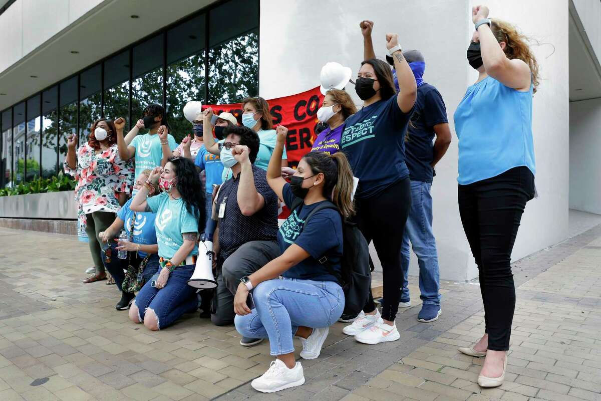 Attendants gather and chant for a photo during a rally of some 20 supporters to demand passage of an essential workers board to advocate for workplace health and safety Tuesday, Oct. 26, 2021 outside of the Harris County Commissioner’s Court building in Houston, TX.