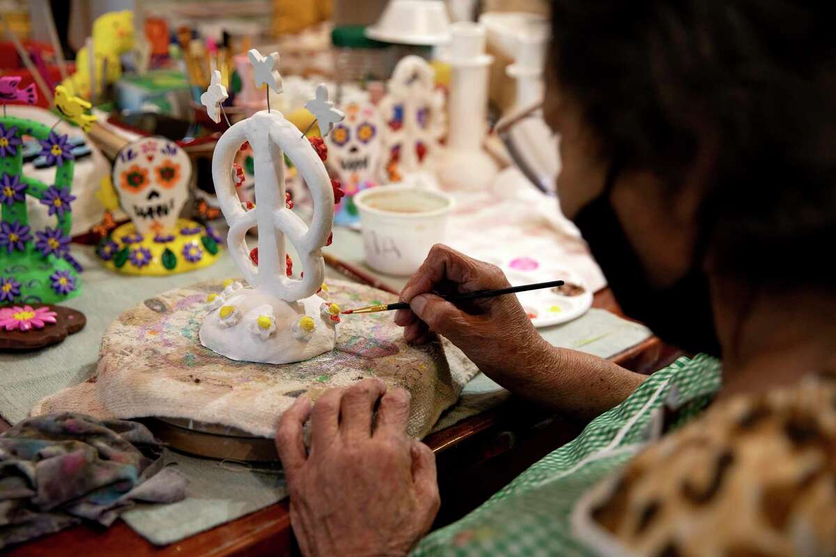 Hilda Ruiz paints a ceramic statue she made at Riconcito de Esperanza for people to use in their Dia de los Muertos altars.