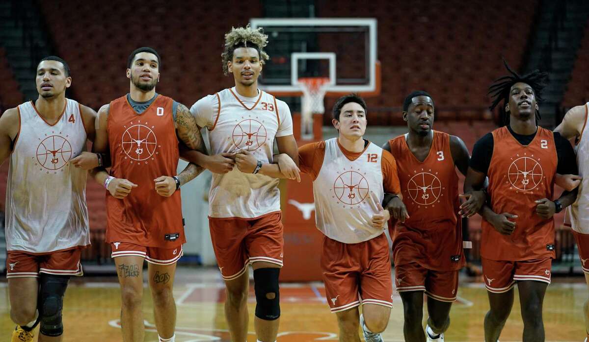 In this Tuesday, Oct. 19, 2021, photo, Texas forward Dylan Disu (4), forward Timmy Allen (0), forward Tre Mitchell (33), guard Tristen Licon (12), guard Courtney Ramey (3) and guard Marcus Carr (2) runs drills during a practice at the team's facility in Austin, Texas. (AP Photo/Eric Gay)