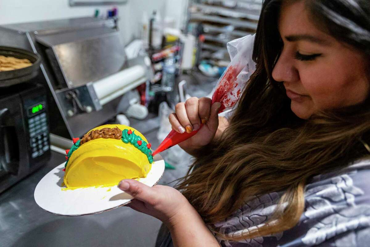 Alexis Quiroga, owner of Pawsitively Sweet Bakery, makes a taco-shaped cake for a dog Oct. 21, 2021 in her Blanco Road shop.
