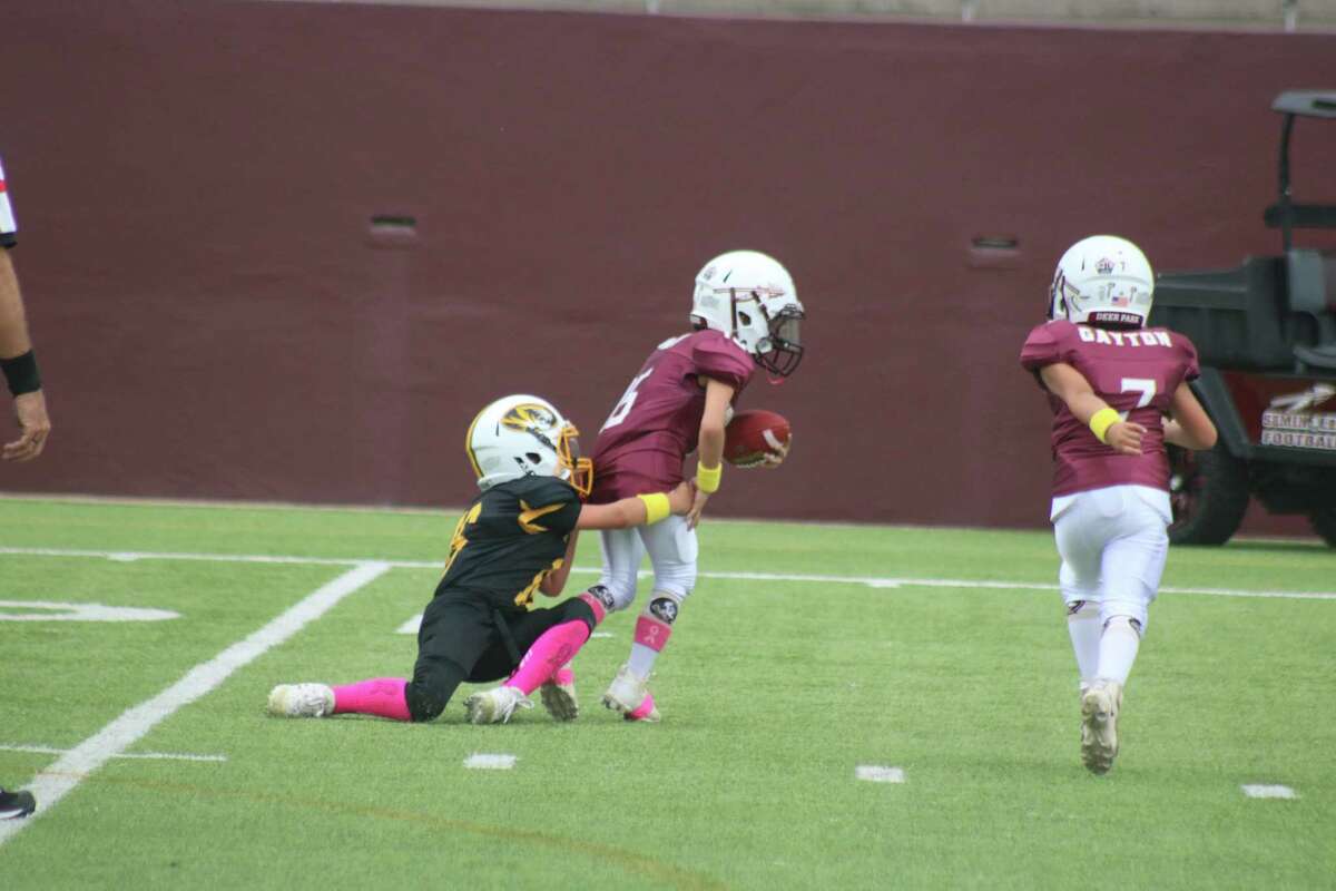 A Deer Park Pee Wee Tiger has the Seminole quarterback in his grasp during their weekend meeting at Abshier Stadium.