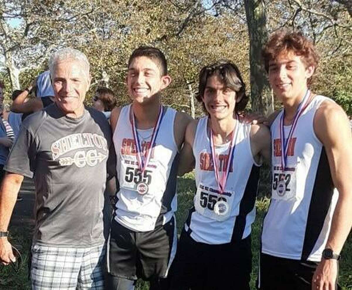 Will Rodrigues, Luke Pacheco and Jayden Opper stand alongside coach Mike Gambardella after the trio earned second-team All-SCC honors at the league championship meet.