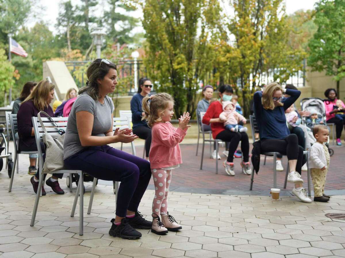 Greenwich's Sydney Maczko, 3, and her nanny Thais Triers, clap during an activity at Storytime in the Courtyard at Greenwich Library in Greenwich, Conn. Monday, Oct. 25, 2021. Kids enjoyed Halloween-themed stories and activities outdoors in Baxter Courtyard Monday morning.