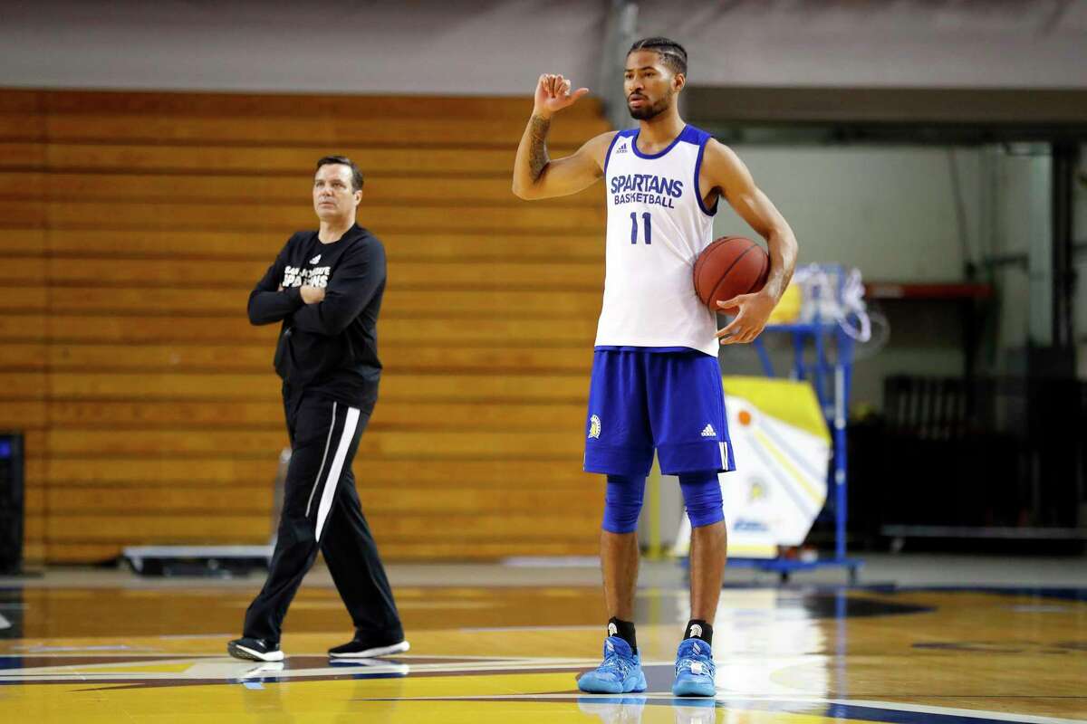 San Jose State University basketball player Richard Washington Jr. practices as head coach Tim Miles walks behind him in San Jose, Calif., on Monday, October 25, 2021. In September, Washington, SJSU's best player, was suspended the entire 2021-22 season by the NCAA for signing with a non-certified agent as he tested NBA draft waters and got paid for a 3-on-3 event in Indianapolis.