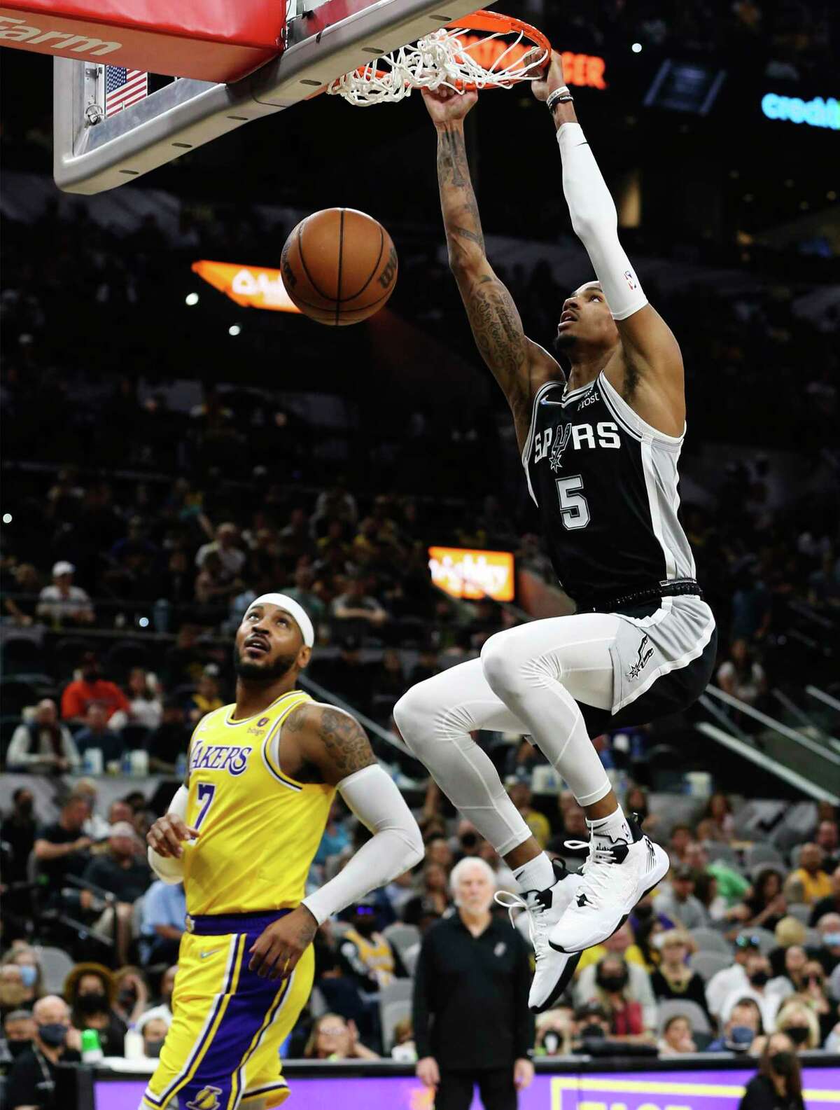 Spurs' Dejounte Murray (05) dunks against Lakers' Carmelo Anthony (07) in the first half at the AT&T Center on Tuesday, Oct. 26, 2021.