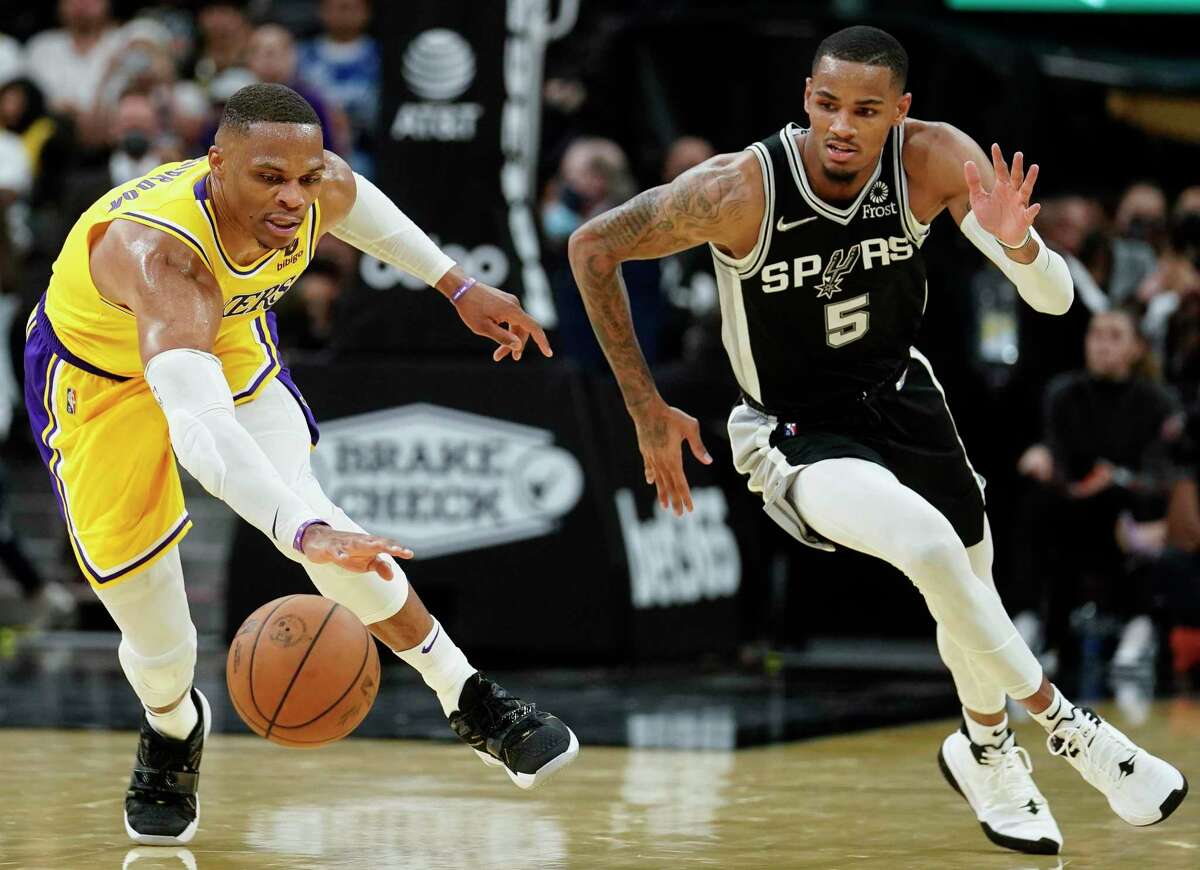 Los Angeles Lakers' Russell Westbrook, left, and San Antonio Spurs' Dejounte Murray chase the ball during the first half of an NBA basketball game on Tuesday, Oct. 26, 2021, in San Antonio, Texas. (AP Photo/Darren Abate)