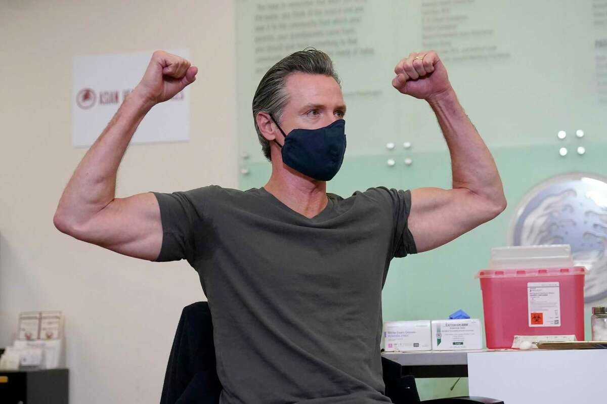 Gov. Gavin Newsom gestures after receiving a Moderna COVID-19 vaccine booster shot at Asian Health Services in Oakland on Oct. 27, 2021.