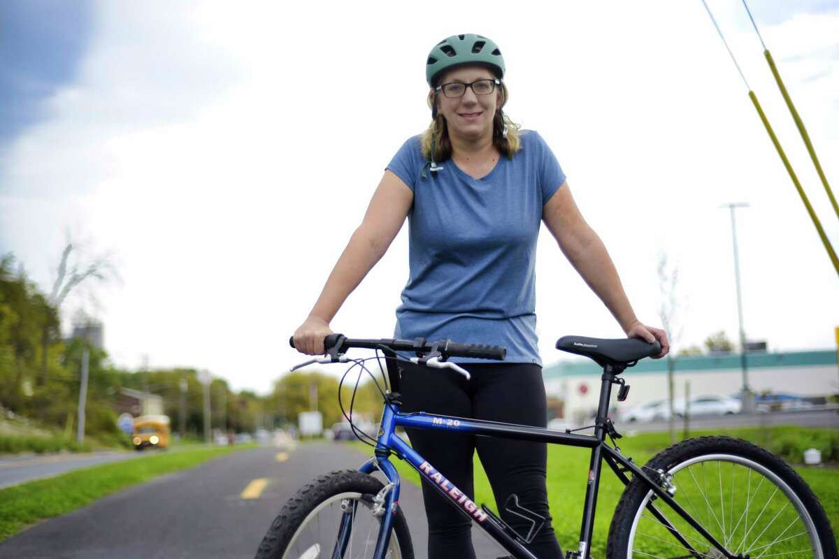Sandy Misiewicz, executive director of the Capital District Transportation Committee, stands with her bicycle along the Albany South End Multi-use Trail on Thursday, Oct. 21, 2021, in Albany, N.Y.