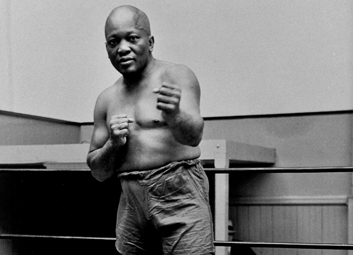 FILE - In this 1932 file photo, boxer Jack Johnson, the first black world heavyweight champion, poses in New York City. A Texas Gulf Coast home where Johnson once lived has been heavily damaged in a fire. The blaze caused a wall to collapse in the vacant home Friday, April 5, 2019 in Galveston, Texas. Fire Chief Mike Wisko said that the building was in the process of being renovated. (AP Photo/File)
