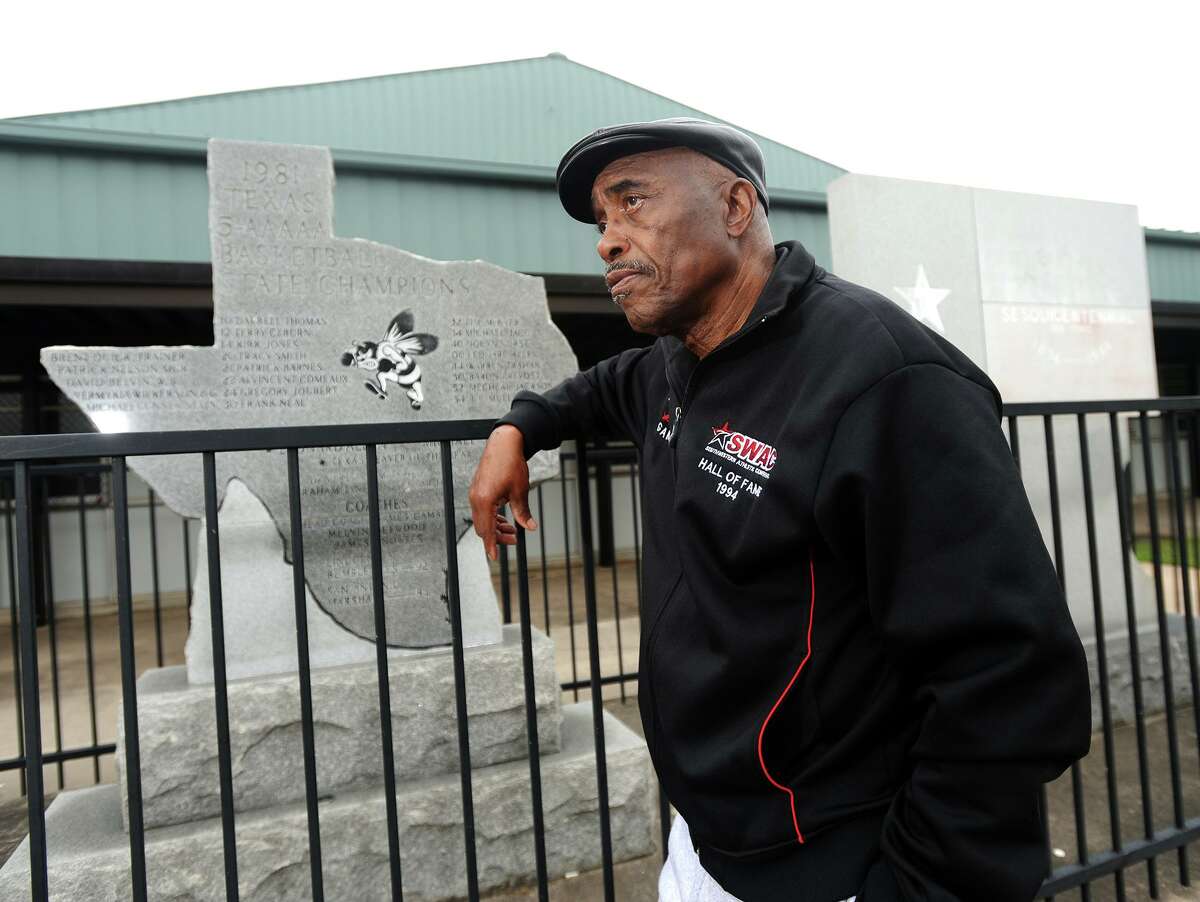James Gamble poses for a photo next to monuments honoring the teams he led to state championships. Gamble, former basketball coach at Port Arthur's Lincoln High School, posed for pictures and spoke with the Beaumont Enterprise at the school on Monday afternoon. Between 1981 and 1991, the school made it to nine state championships, bringing home the title seven times. Photo taken Monday, 2/24/14 Jake Daniels/@JakeD_in_SETX