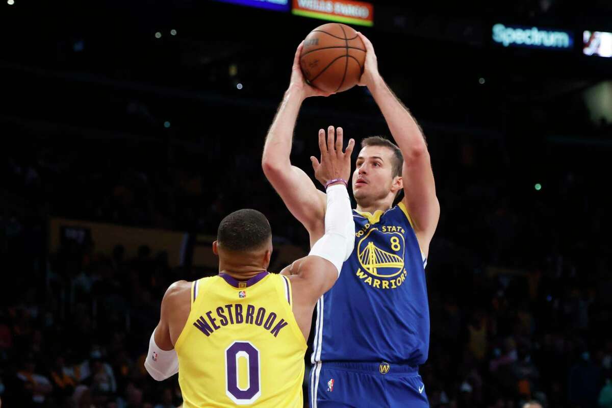 Golden State Warriors forward Nemanja Bjelica (8) shoots over Los Angeles Lakers guard Russell Westbrook (0) during the second half of an NBA basketball game in Los Angeles, Tuesday, Oct. 19, 2021. The Warriors won 121-114. (AP Photo/Ringo H.W. Chiu)