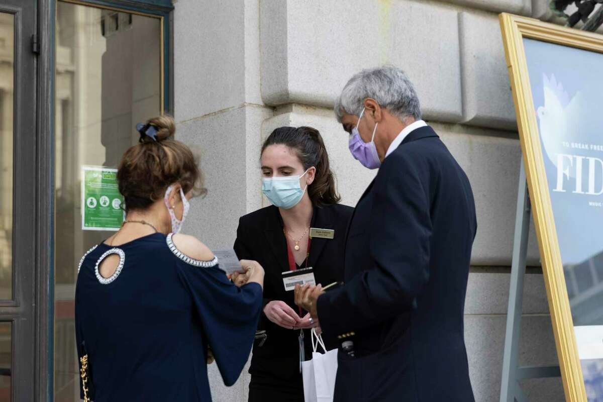 Kate Juliana (center) checks for vaccination proof from guests while working at the War Memorial Opera House in San Francisco.