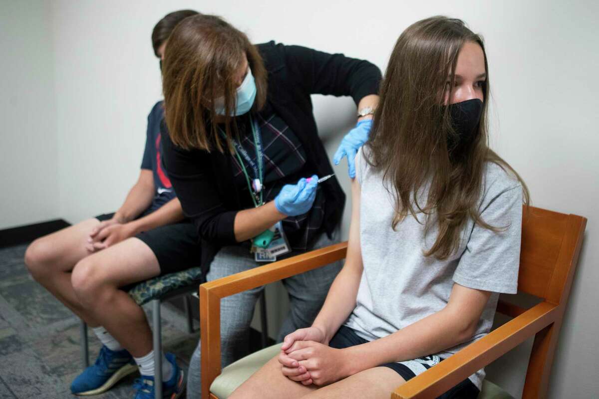 Caitlin Hunt, 14, receives a dose of the Pfizer BioNTech COVID-19 vaccine from registered nurse Lisa Icard at Baylor College of Medicine Wednesday, May 12, 2021 in Houston. Hunt, with her twin brother, Christopher, were in the group of first teenagers to receive the COVID-19 vaccine in the Houston area, less than two hours after federal health officials officially recommended the distribution of the vaccine to 12- to 15-year-olds nationwide.