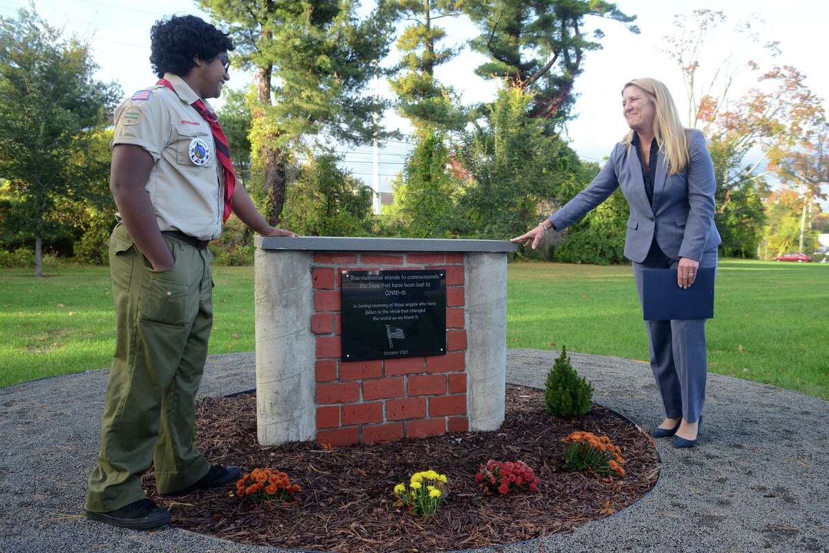 First Selectwoman Brenda Kupchick speaks with Lin Sunil during a dedication ceremony for a new COVID-19 Memorial at Jennings Park, in Fairfield, Conn. Oct. 27, 2021. Sunil, a senior at Fairfield Warde High School, is a member of Boy Scouts of America Troup 82, and designed and built the memorial for his Eagle Scout project.
