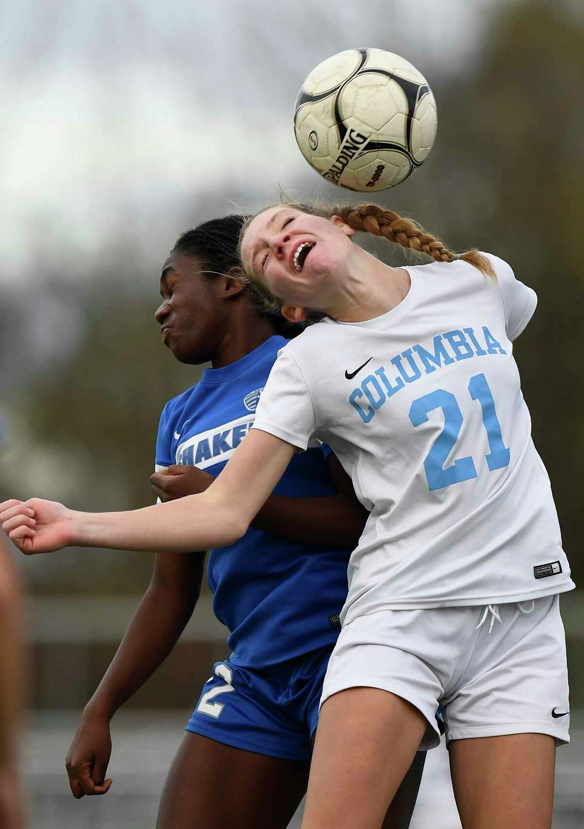 Columbia’s Ella Hebler (21) heads the ball while being defended by Shaker’s Vivian Nartey (22) during their Class AA girls' soccer semifinal last year.