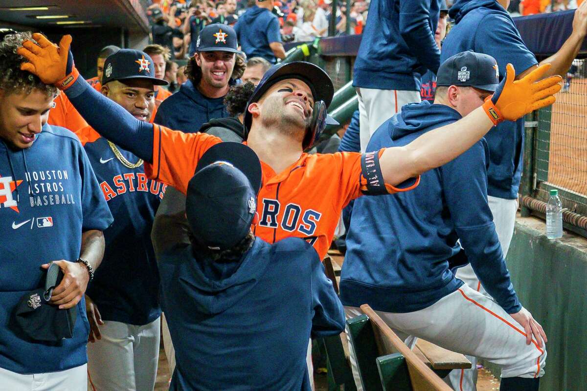 Garrett Stubbs picks up Houston Astros second baseman Jose Altuve (27) as the team celebrates in the dugout after Altuve hit a solo home run to give the Astros a 7-2 lead in the seventh inning in Game 2 of the World Series on Wednesday, Oct. 27, 2021 at Minute Maid Park in Houston.