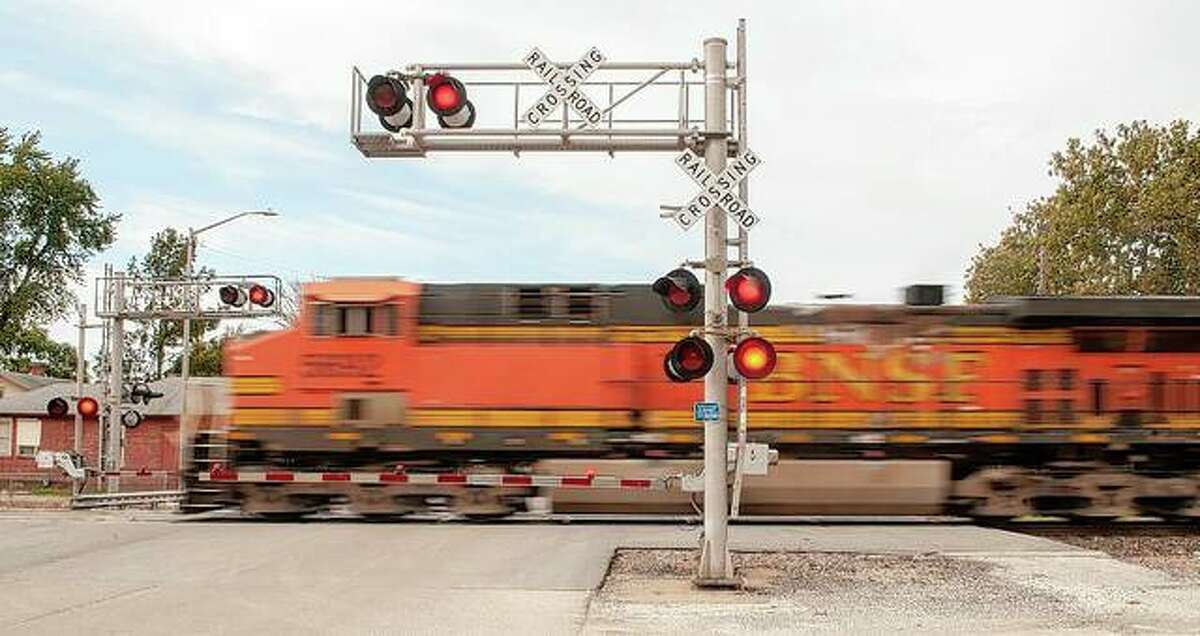 A BNSF Railway train travels through a crossing at East State Street on Wednesday. The Illinois Commerce Commission is requiring the traffic signals at the intersection be relocated, which may require elevation work and changes to the sidewalks. In addition, a pedestrian signal must be installed.