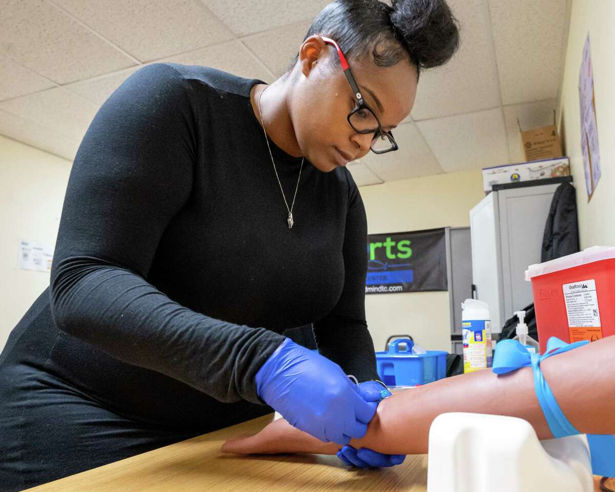 LaQuetta Alexander, a founder and owner of the Hearts and Minds Training Center, demonstrates her technique on a training arm. She and Odaysia Burton-Garland established the medical training center specializing in training phlebotomists and EKG technicians at the Community Loan Fund of the Capital Region small business incubator building on Orange Street in Albany, NY. (Jim Franco/Special to the Times Union)