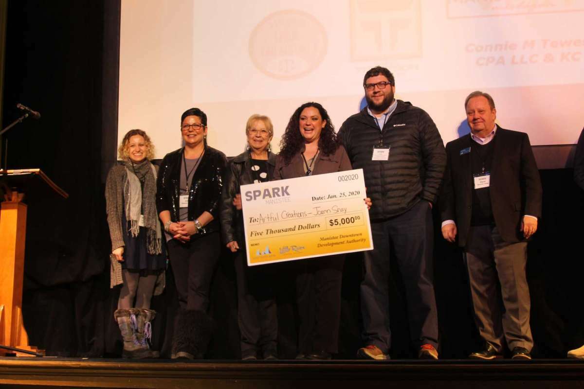 Judges and former Manistee DDA executive director Caitlyn Berard (far left) stand with Spark Manistee winner Joann Snay (center) at the Ramsdell Regional Center for the Arts in 2020. Snay recently announced a new location for her studio in downtown Manistee. 