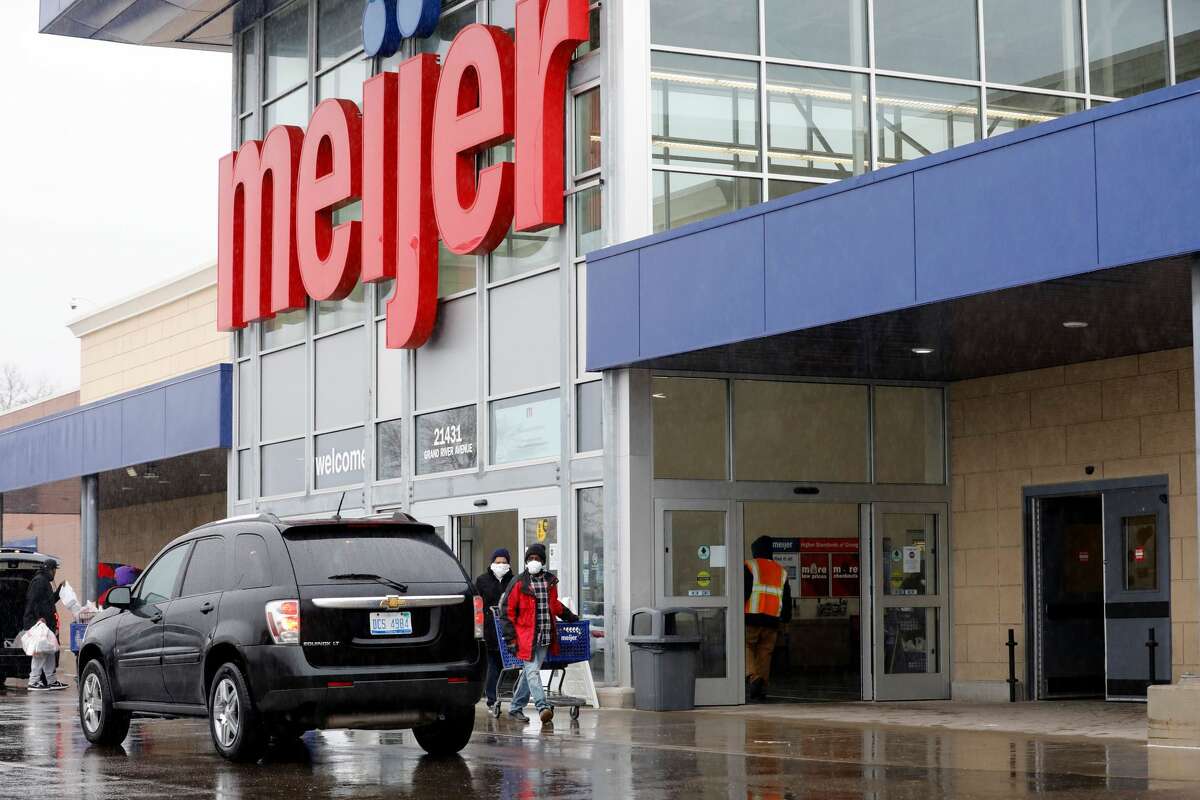 FILE — People wear face masks as they leave a Meijer store in Detroit, Michigan on April 7, 2020. (Photo by JEFF KOWALSKY / AFP)